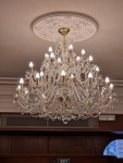 Eine goldene Version des Kronleuchters, modifiziert für eine niedrige Decke in einer Hotelrezeption