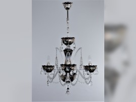 Die Kombination aus silbernem Hochemaildekor und silbern glänzenden Metallteilen des Kronleuchters hebt sich von dem schwarzen (Hyalit-)Glas ab.