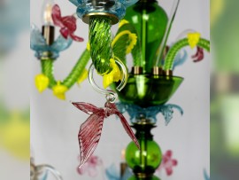 Glas-Schmetterlinge an den grünen Glasarmen des Kronleuchters
